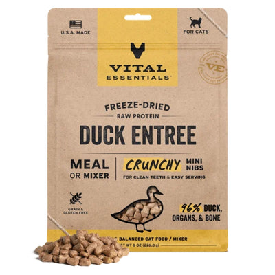 A brown and yellow pouch of Vital Essentials freeze-dried duck cat food with a pile of mini nibs in front.