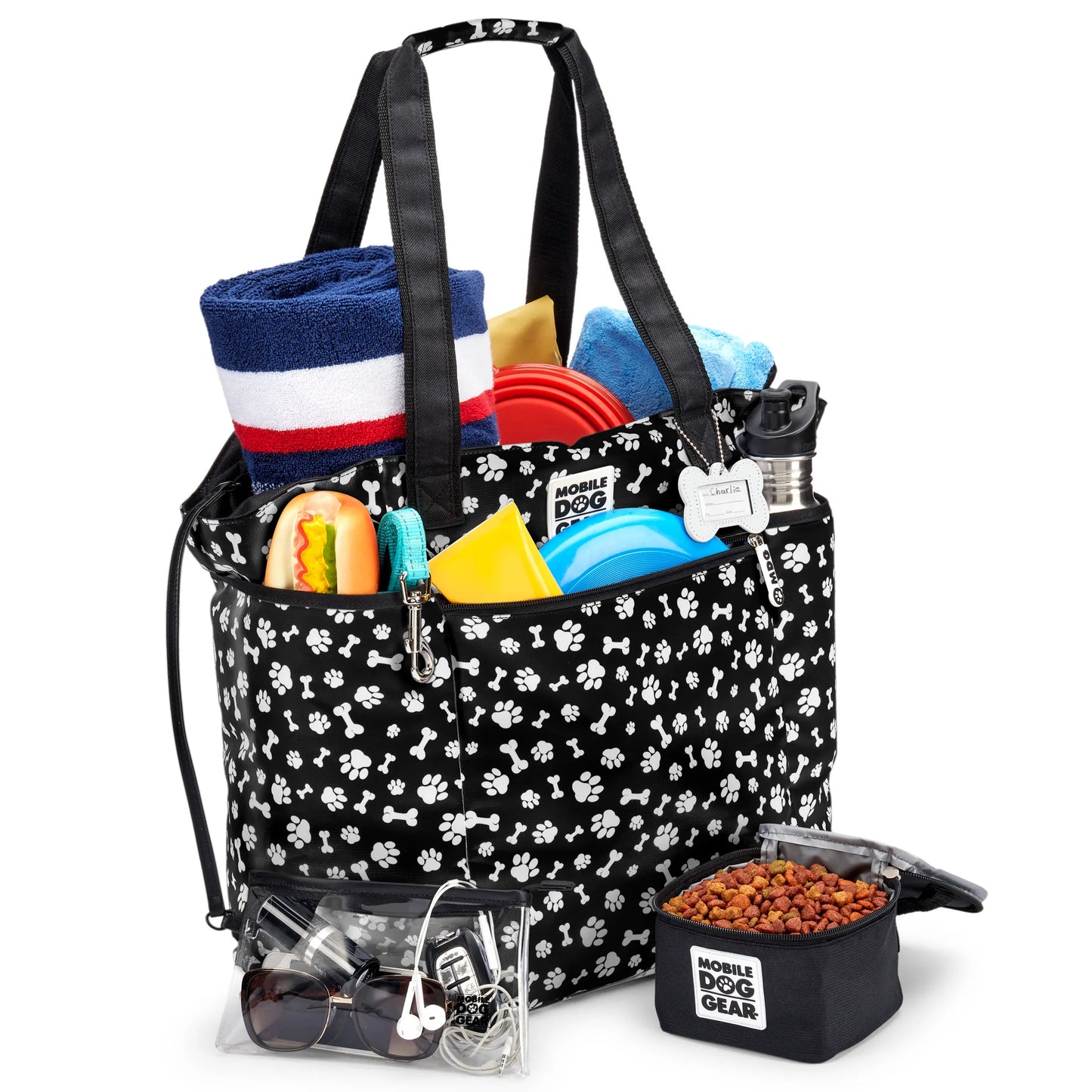Mobile Dog Gear Dogssentials Tote Bag filled with towels, dog toys, water bottle, and collapsible food bowl for pet supplies.